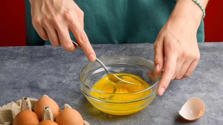 Person whisking eggs with a fork