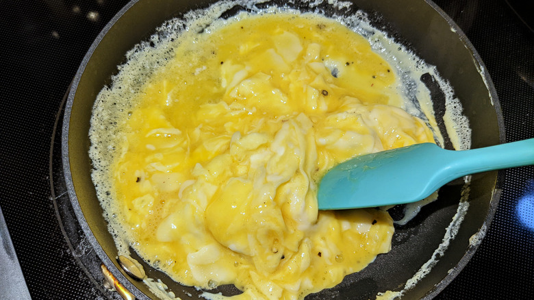 Scrambled eggs stirred with spatula