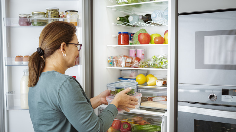 woman taking food out of fridge