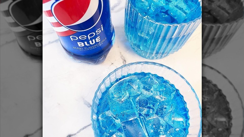 Two glasses and a bottle of Pepsi Blue on a table