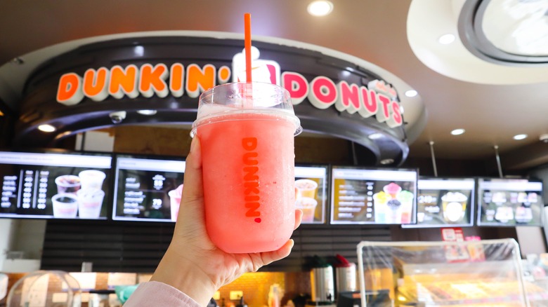 A person holding a Dunkin Donuts iced drink