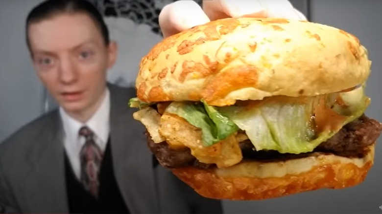 person holding loaded nacho cheeseburger