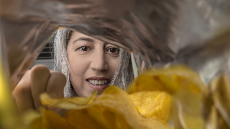 woman eating chips from a near-empty bag