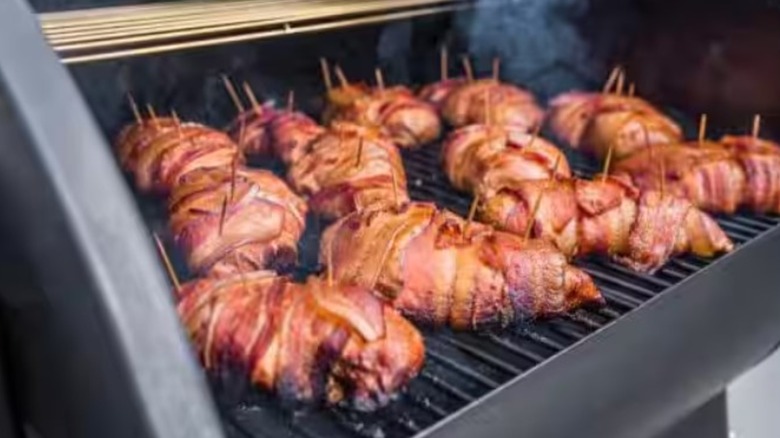 Bacon-wrapped meat cooking on a Camp Chef pellet grill