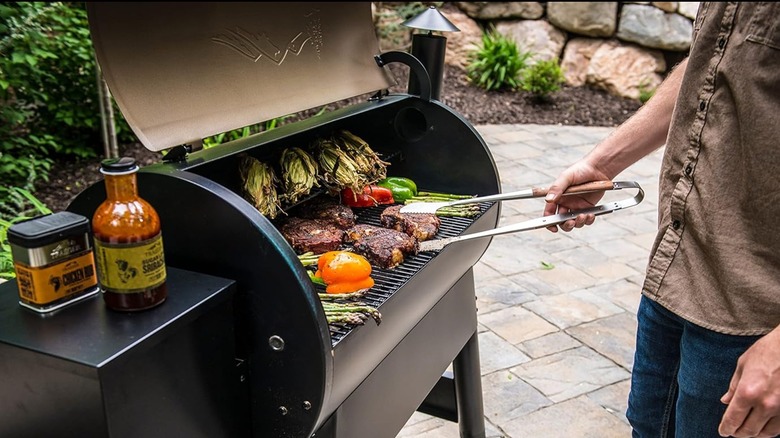 A man grilling at a Traeger pellet grill