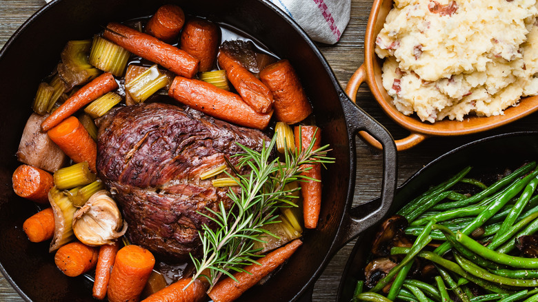 Pot roast beef in a pan with roast vegetables