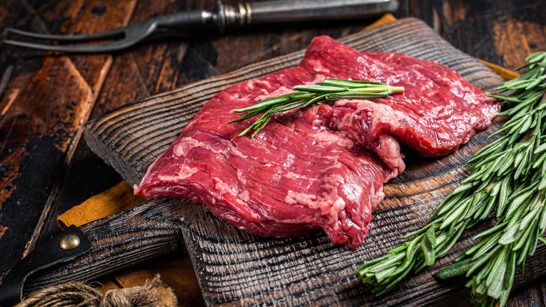 Raw skirt steak garnished with rosemary