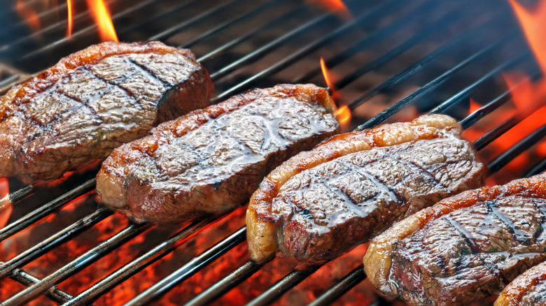 Picanha steaks cooking on a flame grill