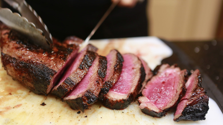 Cook slicing rare steak