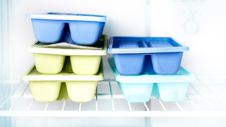 stacked ice cube trays in freezer