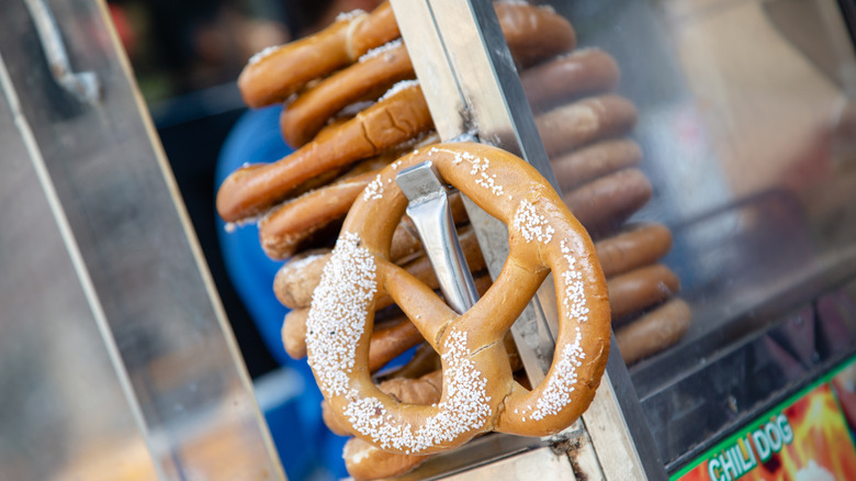 A soft pretzel hanging on a cart