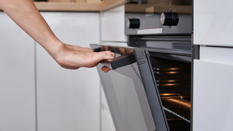 hand opening the oven
