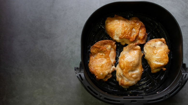 Chicken thighs in an air fryer basket