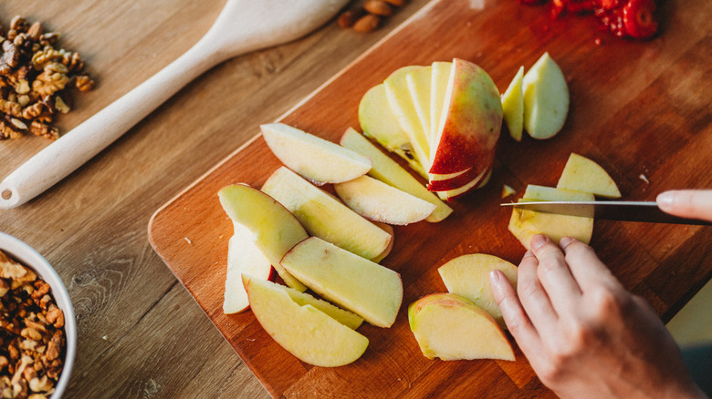 slicing an apple on cutting board