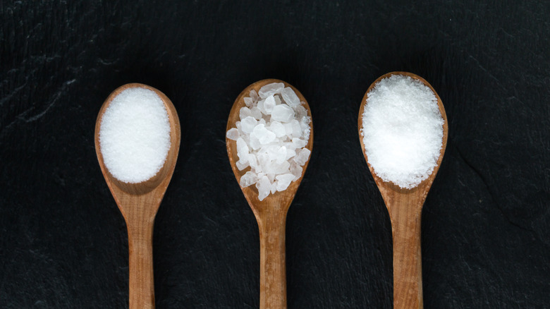 three different types of salt on wooden spoons