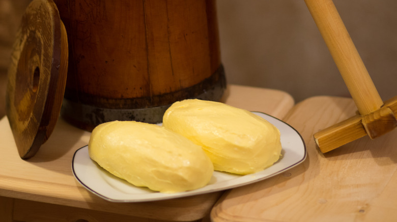 hand-made butter in front of a wooden churn