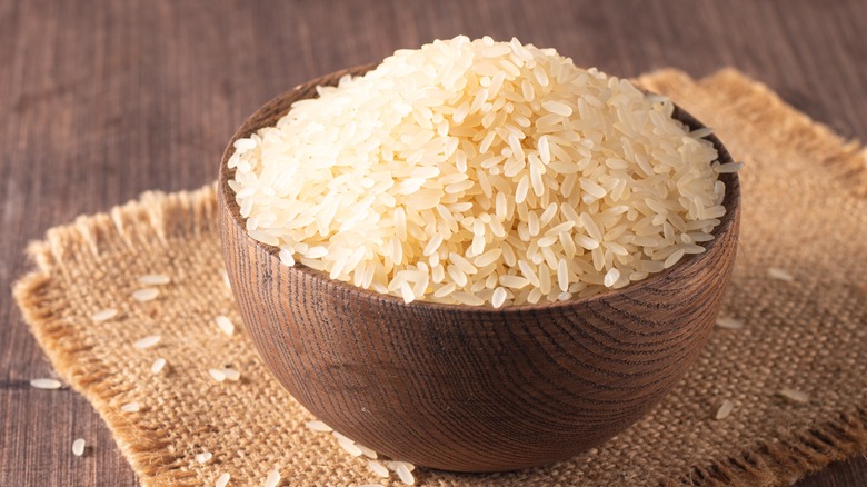 heap of white rice in a wooden bowl