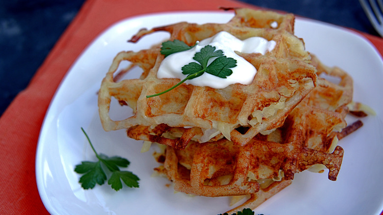 two hash browns made in a waffle iron, on a white plate