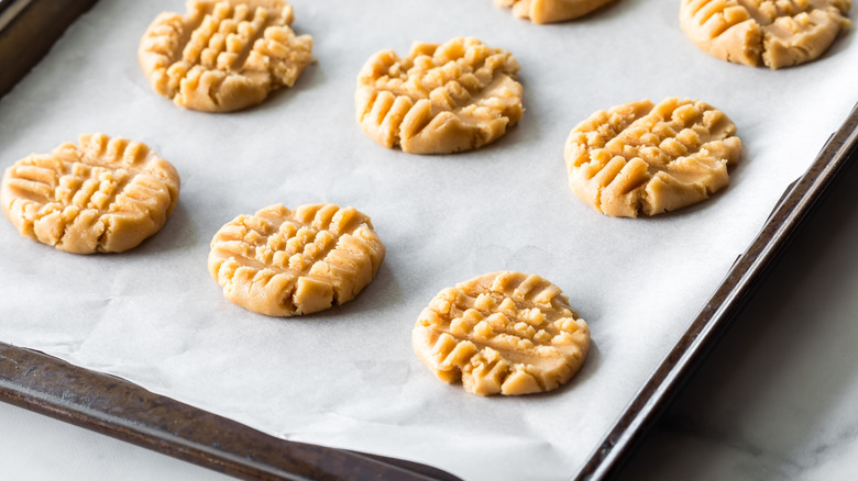 a parchment-lined sheet pan with uncooked cookies on top