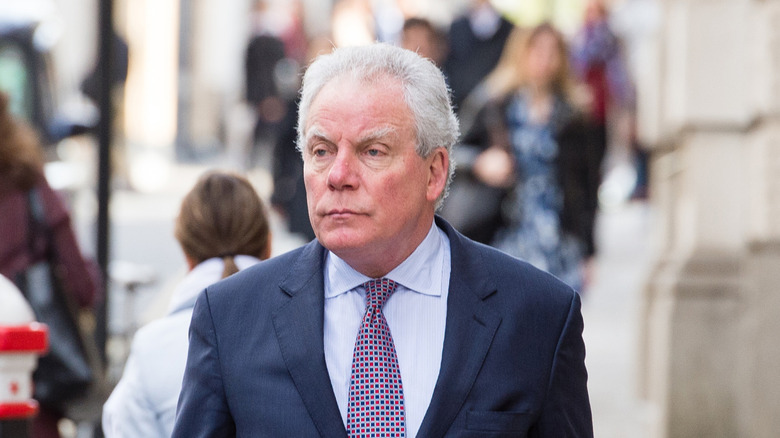 Chris Hutcheson, wearing a suit and walking down a London street