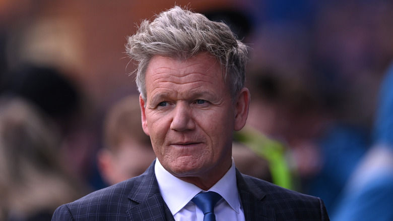 Chef Gordon Ramsay wearing a blue checkered jacket, white shirt and blue tie