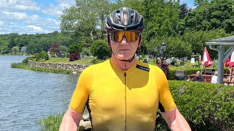 Gordon Ramsay wearing a black cycling helmet and yellow jersey