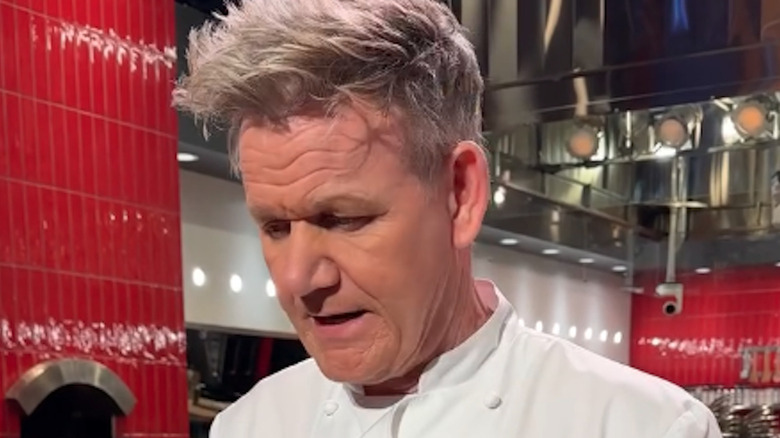 Gordon Ramsay in a kitchen looking down