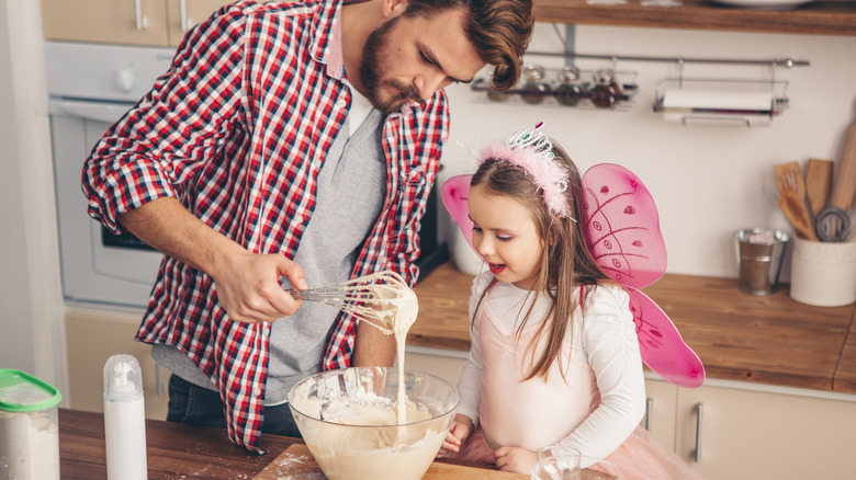 father and daughter making cake
