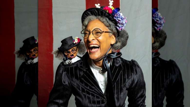 Carla Hall in costume with a puppet 