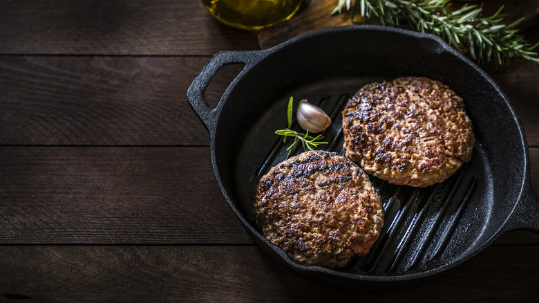 Two beef burgers in a pan