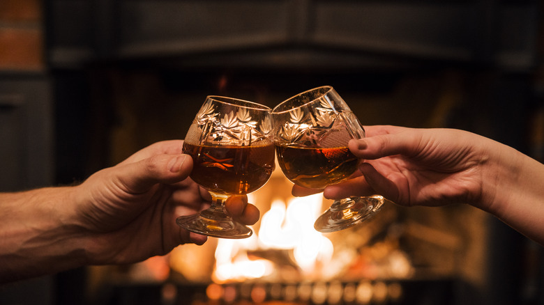 A couple toasting with brandy glasses