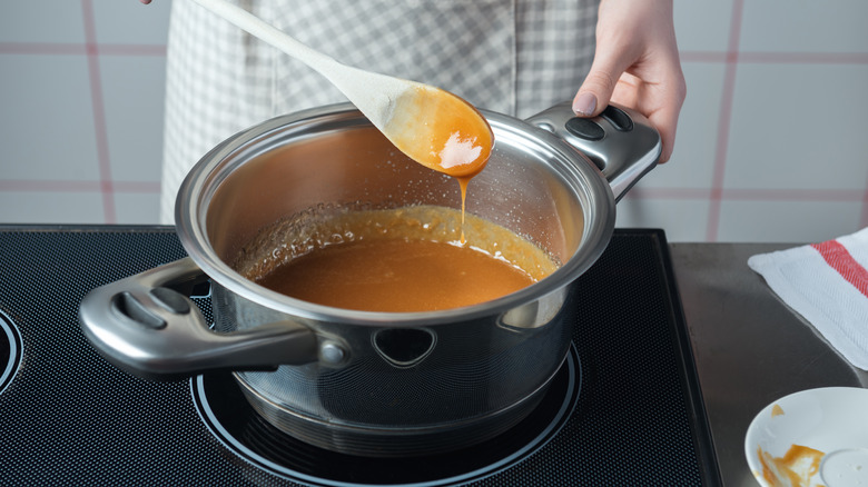 A person stirring caramel in a pan