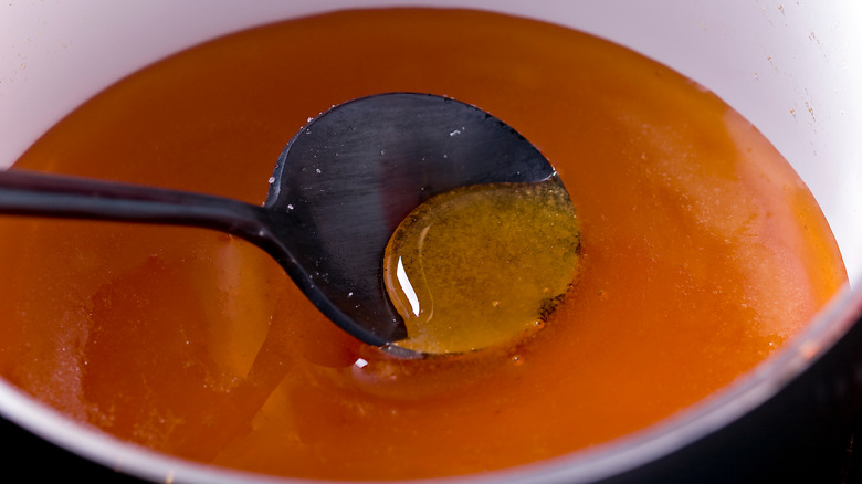A spoon being dipped into caramel