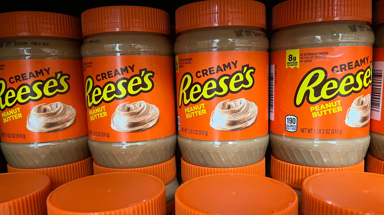 Jars of creamy Reese's peanut butter on display on a store shelf