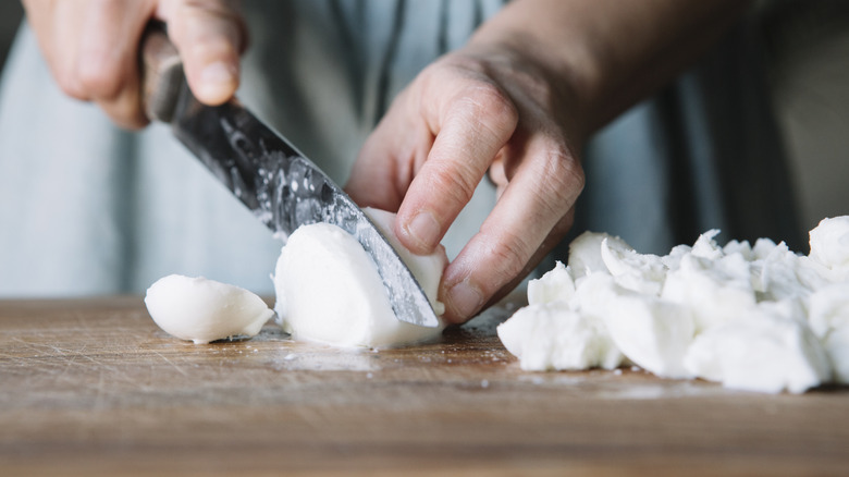 man cutting mozzarella