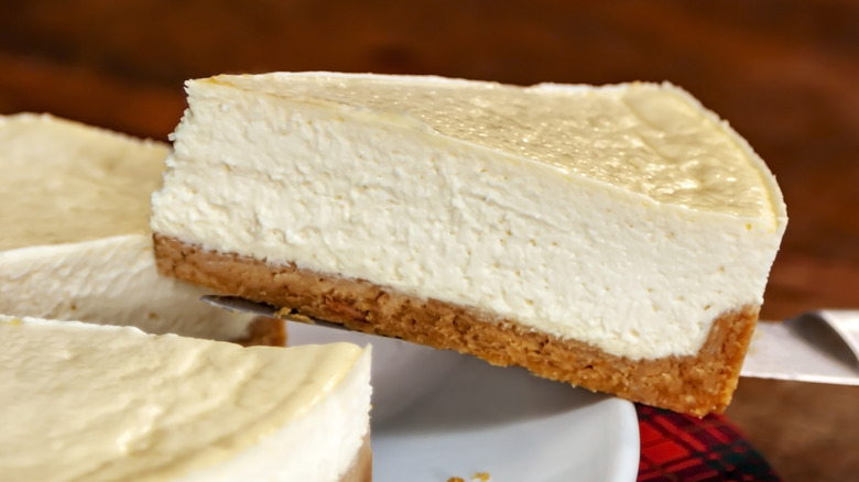 slice of cheescake being removed from cake