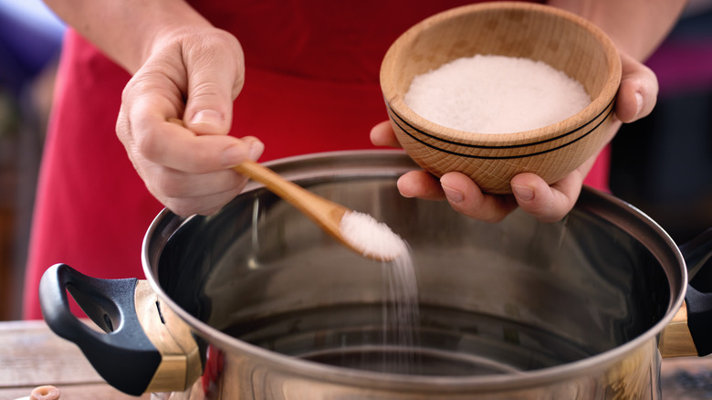 adding salt to pot of water