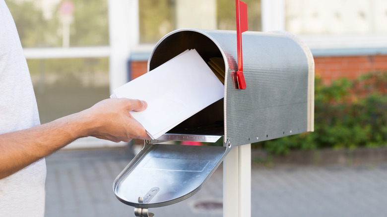 A person putting a letter in the mail