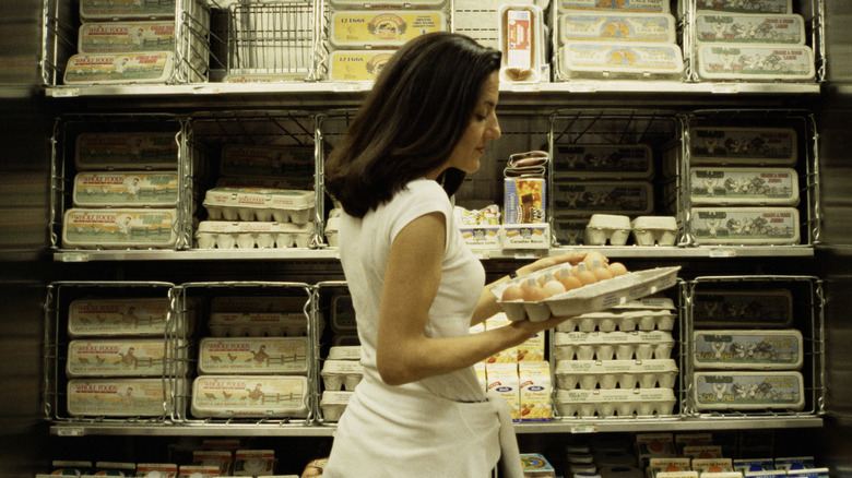 Woman examining eggs in the grocery store