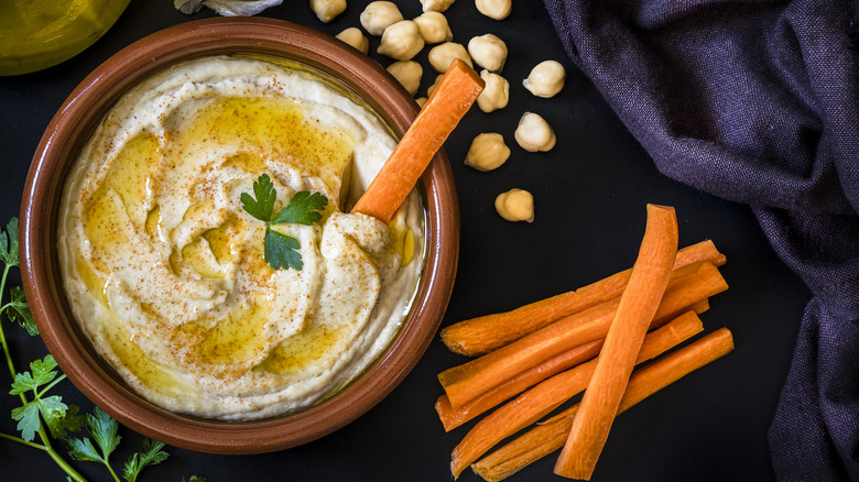 Hummus with carrot sticks and herbs