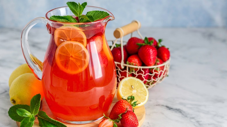 A cocktail jug with strawberries and lemon