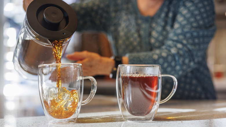 Person pouring tea from french press
