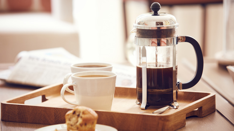 A French press and coffee cups
