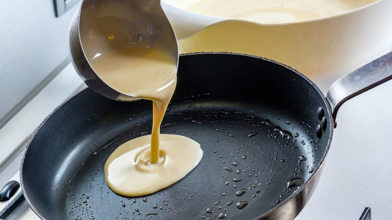 ladling pancake batter onto skillet