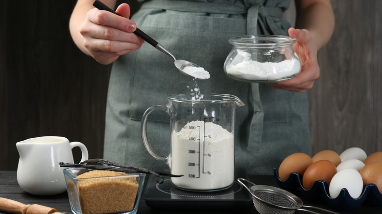 adding baking powder to measuring cup