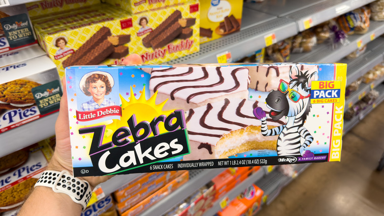 Hand holding box of Little Debbie Zebra Cakes