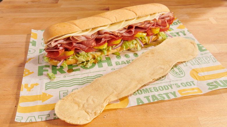 large potato chip next to footlong sandwich