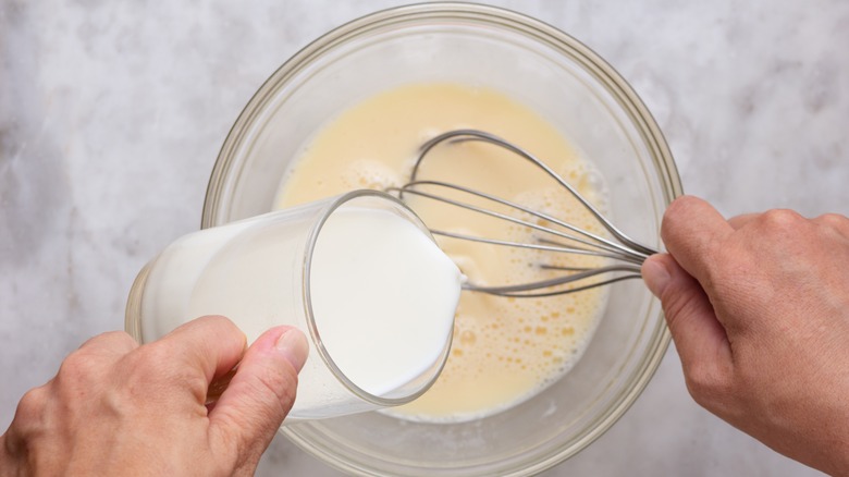 pouring milk into eggs