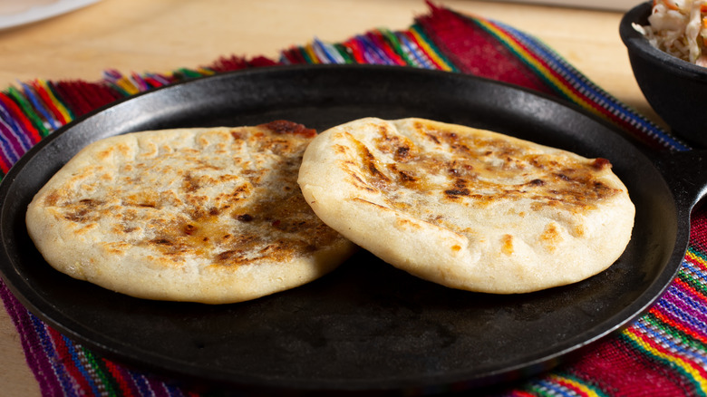 two flat breads on a black skillet