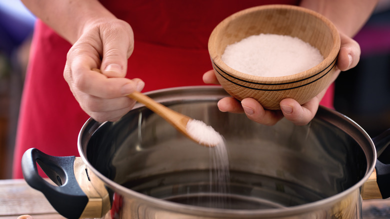 adding salt to pot of water